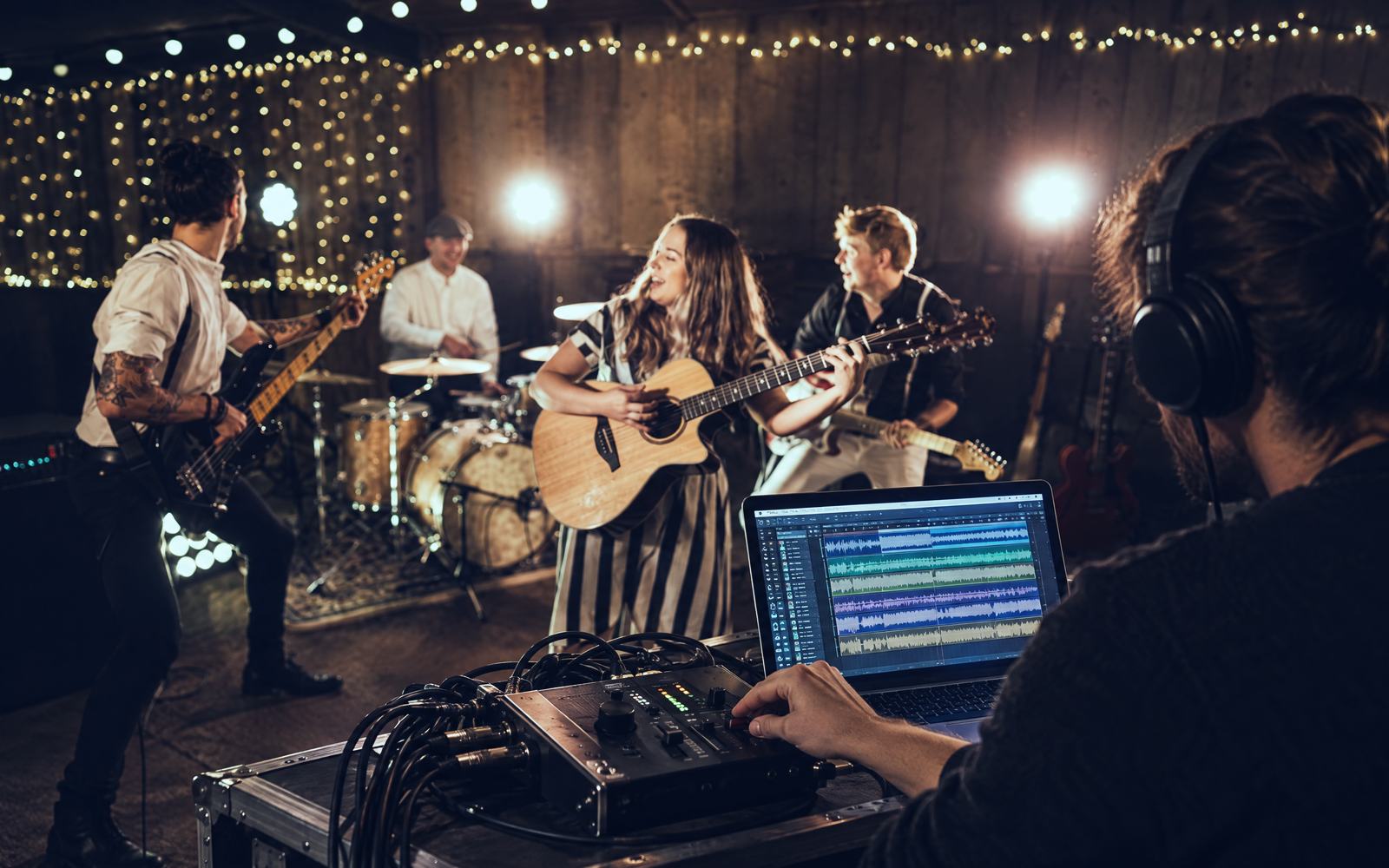 An engineer in headphones tracking The Everglow at a barn session